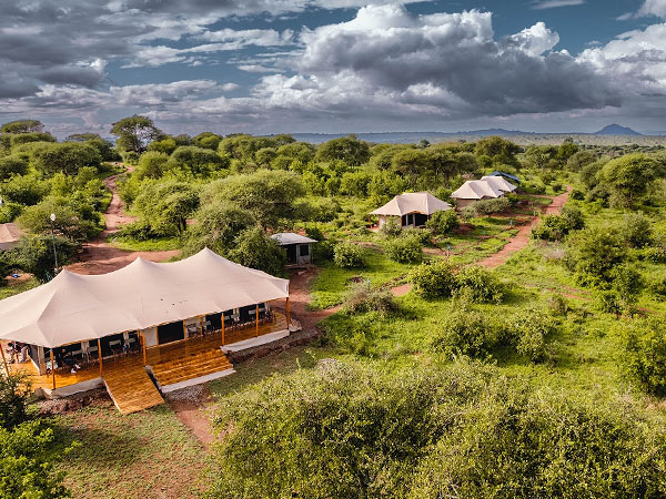 Aerial view of Angata camp with cream tents and lush surroundings