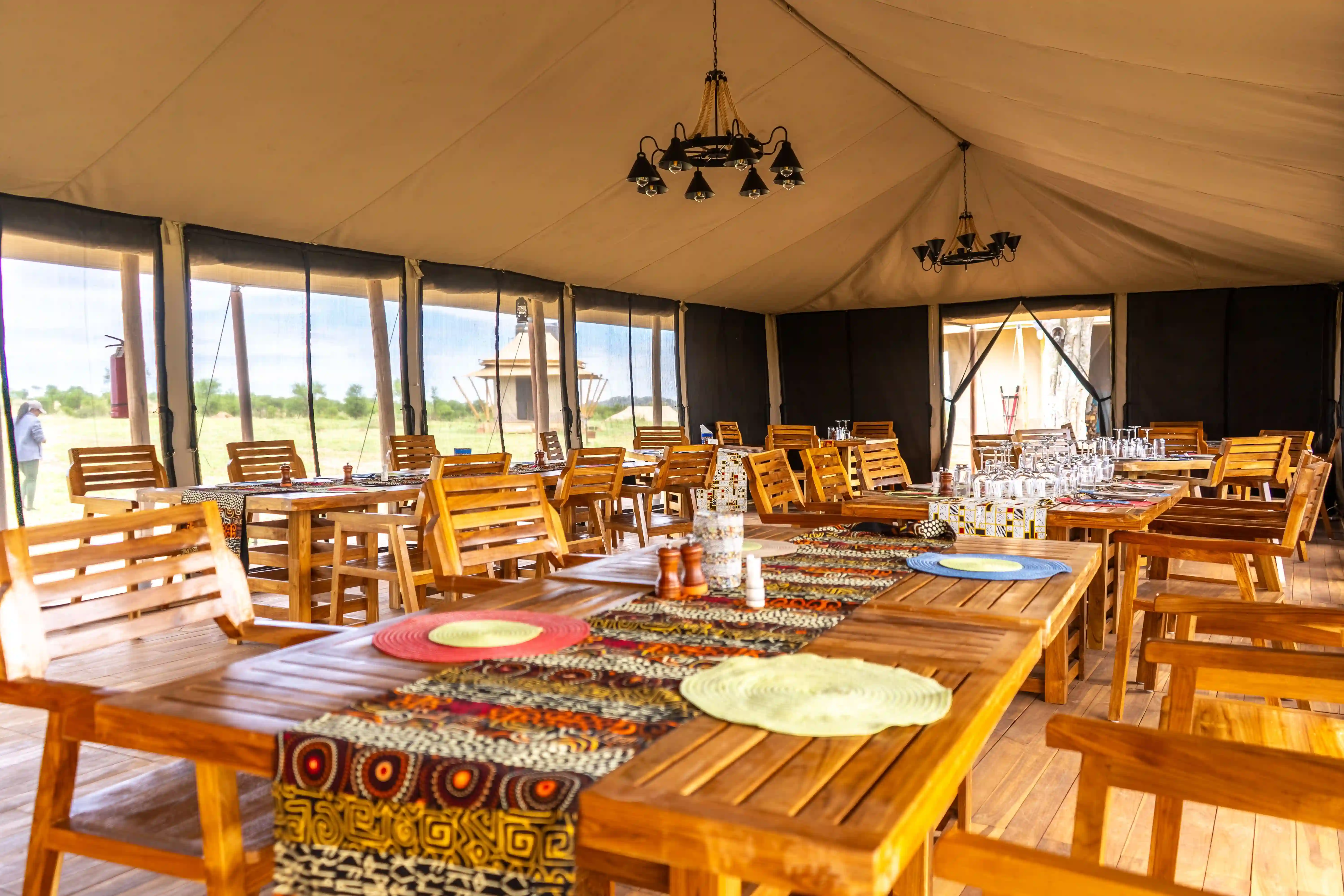 Large dining tent interior with wooden tables and traditional textiles