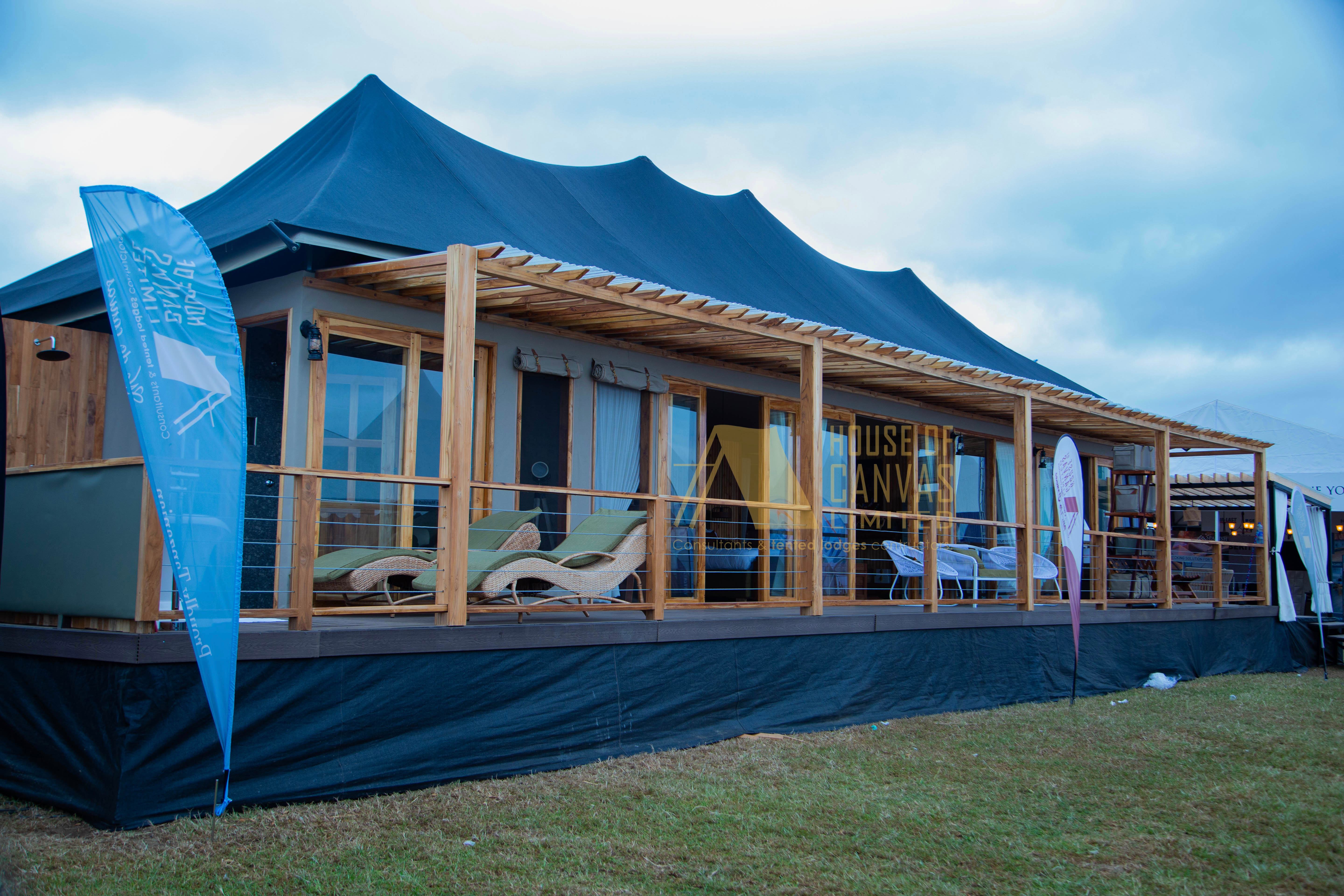 Evening exterior view of House of Canvas tent with professional branding and lighting