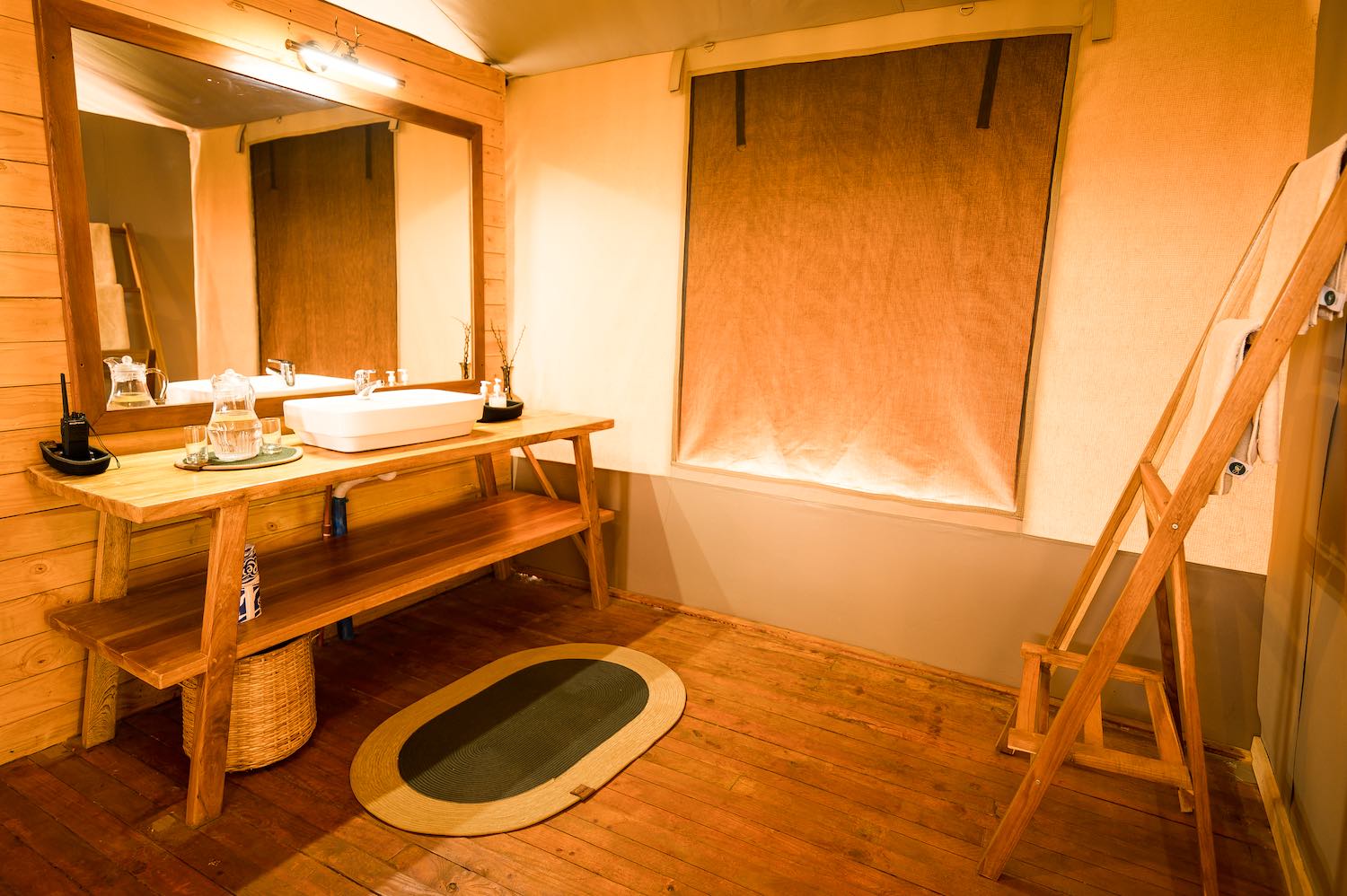 Luxury tent bathroom with wooden fixtures and bathtub