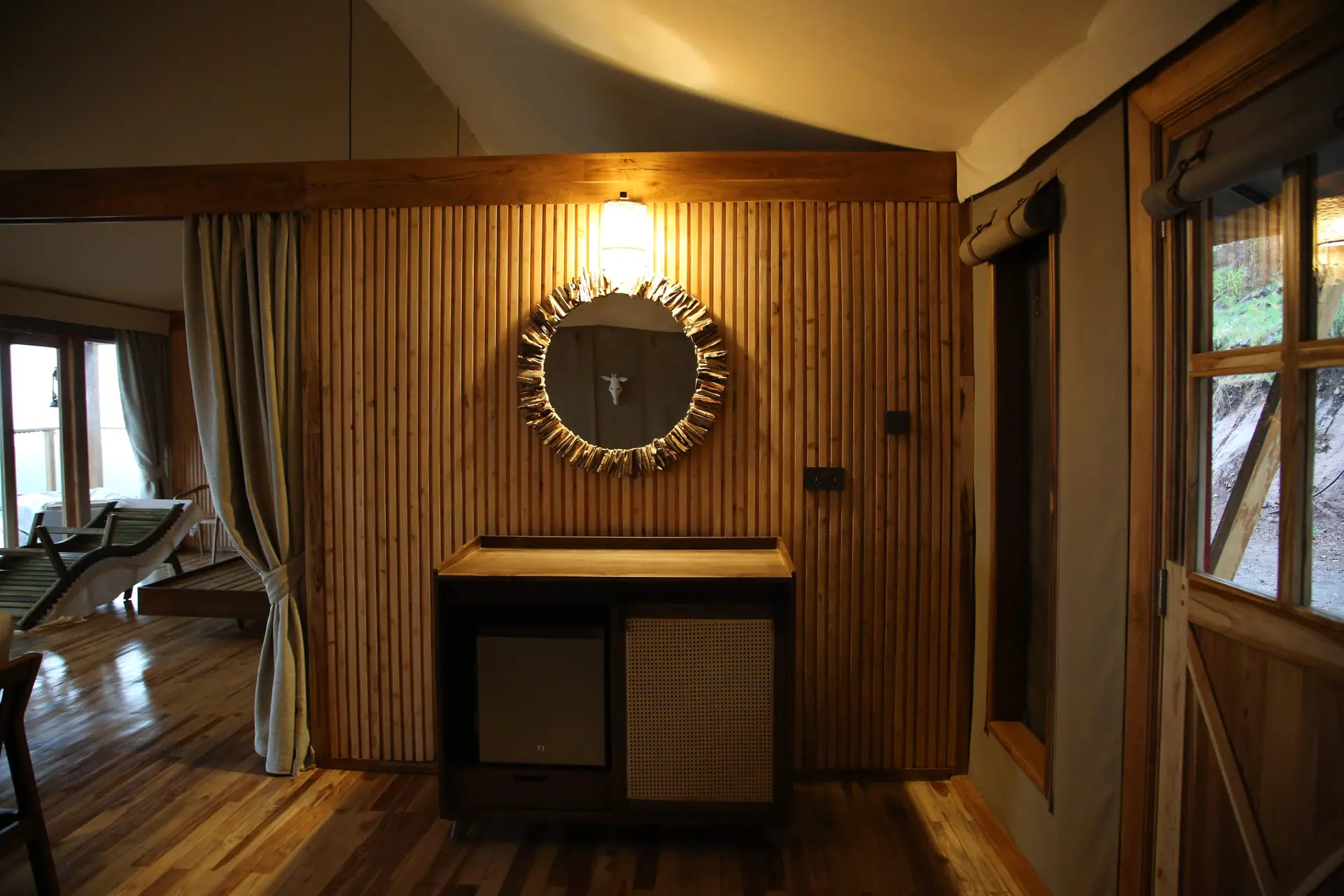 Living room with wooden slat wall, circular mirror, and modern fireplace