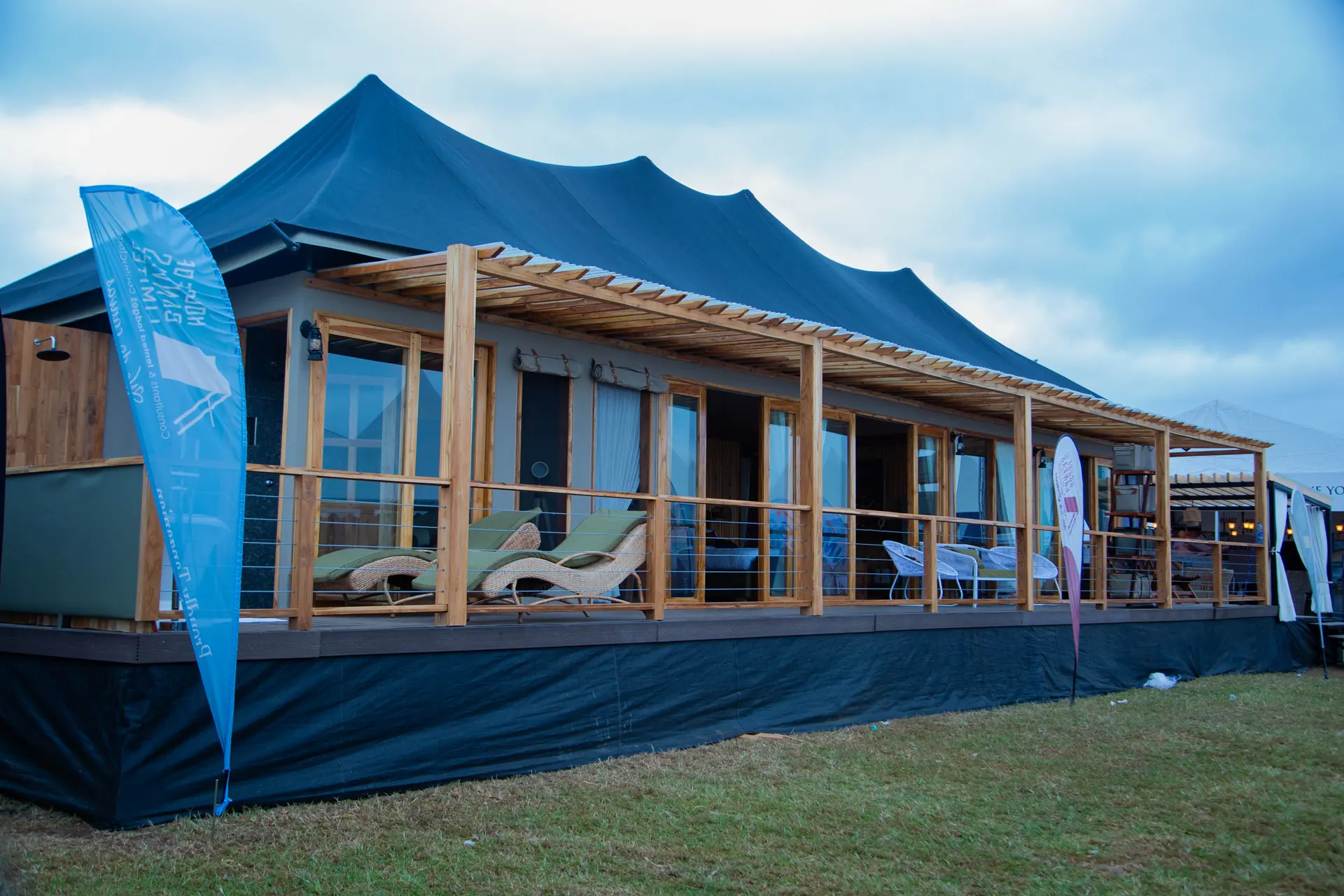 Tent structure with blue roof and wooden deck
